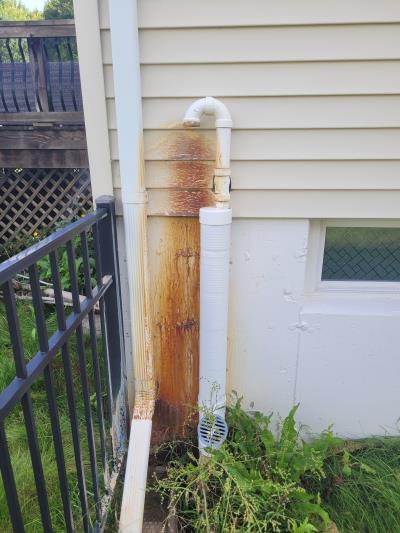 The sump pump drain has caused rust to form on this vinyl siding. Power washing can not remove these stains. Soft Washing did!